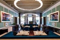 a restaurant with tables and chairs and a chandelier at Radisson Collection Hotel, Palazzo Nani Venice in Venice