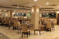 un ristorante con tavoli e sedie e un bar di Magnum Inn a Lahore