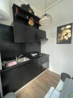 a kitchen with black cabinets and a sink at La clef Sithieu in Saint-Omer