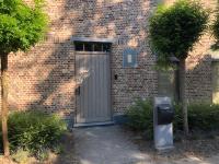 a door to a brick building with a parking meter at landelijke villa met zwembad en gezellige openhaard in Zemst