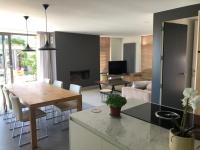 a kitchen and living room with a table and a couch at landelijke villa met zwembad en gezellige openhaard in Zemst