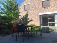 a table and chairs in front of a brick building at landelijke villa met zwembad en gezellige openhaard in Zemst