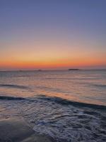 a sunset over the ocean with a beach at Sur le chemin de la plage in Cherbourg en Cotentin