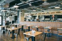 ein Restaurant mit Holztischen und Stühlen und einer Bar in der Unterkunft Holiday Inn Chicago O'Hare - Rosemont by IHG in Rosemont