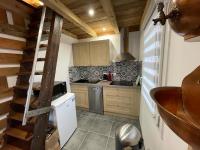 a small kitchen with a staircase in a house at La cabane de dany in La Bresse