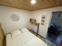 a small bedroom with a white bed and a window at La cabane de dany in La Bresse
