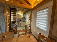 a kitchen with a table and chairs and a window at La cabane de dany in La Bresse