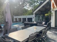 a patio with a table and chairs and a pool at Villa piscine&#47;jacuzzi aux portes de Paris. in Lamorlaye
