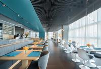 Un restaurante con mesas de madera y sillas blancas. en Pagoda Hotel Shenzhen Familytrip&BusinessTravel, en Shenzhen