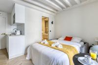 a white room with two beds and a kitchen at New and Designed Studio well Equipped - Heart of Paris 2 in Paris