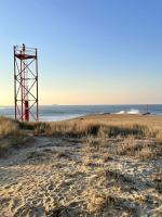 a red tower on a beach next to the ocean at 30 m des Plages - Port du Magouër - 6 invités in Plouhinec