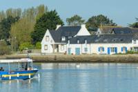 a boat on the water in front of a house at 30 m des Plages - Port du Magouër - 6 invités in Plouhinec