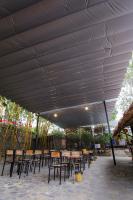 Un grupo de mesas y sillas bajo un techo blanco. en Bavi Homestead, en Ba Vì