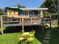 a rv with a table and chairs in the yard at Lou Bohème in Le Briou