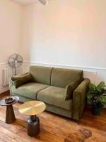 a living room with a green couch and a table at Paris Home in Boulogne-Billancourt