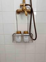 a shower head with three jars on a shelf in a bathroom at Paris Home in Boulogne-Billancourt