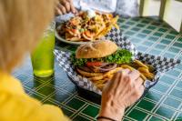 a table with a sandwich and french fries and a drink at 1905 Basin Park Hotel in Eureka Springs