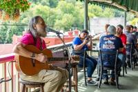a man playing a guitar in front of a microphone at 1905 Basin Park Hotel in Eureka Springs