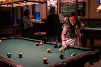 a woman playing pool in a pub at 1905 Basin Park Hotel in Eureka Springs