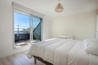 a white bedroom with a bed and a large window at Parenthese relaxante les pieds dans l eau in Le Tour-du-Parc