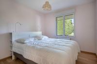 a white bedroom with a large bed and a window at Parenthese relaxante les pieds dans l eau in Le Tour-du-Parc