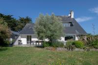 a white house with a tree in the yard at Parenthese relaxante les pieds dans l eau in Le Tour-du-Parc