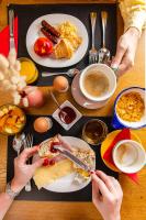 a table with plates of food and people cutting food at Hôtel Crayon in Paris