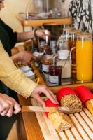 a person cutting a loaf of bread with a knife at Hôtel Crayon in Paris