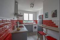 a red and white kitchen with a washing machine at Appart 3 Chambres - 6 personnes - Mémorial - Université in Caen