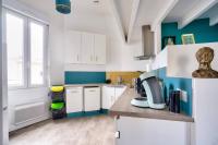 a kitchen with white cabinets and blue walls at Appartement 2 chambres proche gare de Bordeaux in Bordeaux