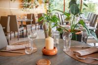 una mesa de madera con gafas y una vela. en Logis Hostellerie la Chaumière, en Arsonval