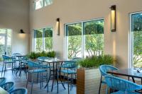 Un restaurante con mesas, sillas y ventanas. en SpringHill Suites by Marriott Orlando at FLAMINGO CROSSINGS Town Center-Western Entrance, en Orlando
