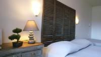 Un dormitorio con una cama y una lámpara en un tocador en Hôtel de l&#39;Océan, en La Rochelle