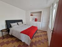 a bedroom with a bed with a red blanket on it at maison PING ,en face des arènes in Béziers