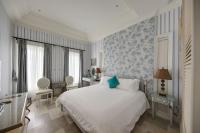 a bedroom with a white bed and blue wallpaper at Kenting 4 Sisters Villa in Eluan