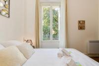 a white bedroom with a bed and a window at 2 pièces tout confort, déco moderne, wifi fibre in Grenoble