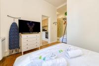 a bedroom with a large white bed and a tv at 2 pièces tout confort, déco moderne, wifi fibre in Grenoble
