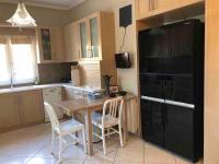 a kitchen with a table and a black refrigerator at Villa Casa Chrissy in Plagiárion