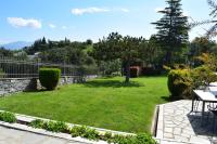 a green yard with a table and a fence at Villa Casa Chrissy in Plagiárion