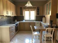a kitchen with wooden cabinets and a table and chairs at Villa Casa Chrissy in Plagiárion