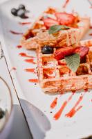 Un plato de waffles con fresas y fruta encima. en Hotel Stomorin-Marina Hramina, en Murter