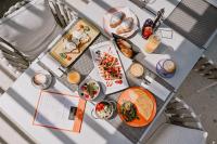 Una mesa con platos de comida y bebidas sobre ella. en Hotel Stomorin-Marina Hramina, en Murter