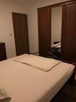 a bedroom with a white bed with wooden cabinets at Villa Predlug in Čapljina