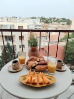 a table with a plate of food and two glasses of orange juice at Massilia Calling love Appartement de standing 8 personnes Marseille proche métro parking facile in Marseille