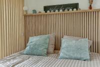 a bed with two blue pillows on top of it at Le Normand- Bois d&#39;arcy in Bois-dʼArcy