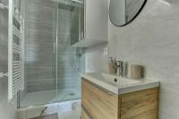 a bathroom with a sink and a shower with a mirror at Le Normand- Bois d&#39;arcy in Bois-dʼArcy