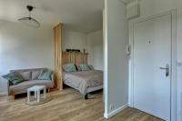 a bedroom with a bed and a couch and a table at Le Normand- Bois d&#39;arcy in Bois-dʼArcy