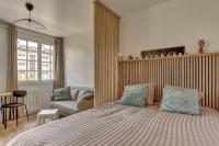 a bedroom with a bed and a chair and a couch at Le Normand- Bois d&#39;arcy in Bois-dʼArcy