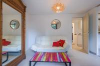 a living room with a white couch and a mirror at Calenzana Trè - Appt avec piscine partagée in Calvi