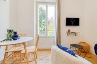 a white living room with a table and chairs at 2 pièces tout confort, déco moderne, wifi fibre in Grenoble